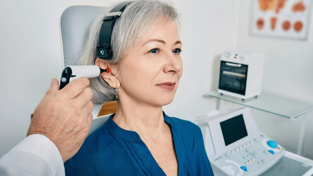 A woman sited being test on her ear with otoscope